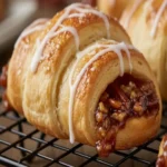 Pecan pie crescent roll drizzled with caramel sauce close-up